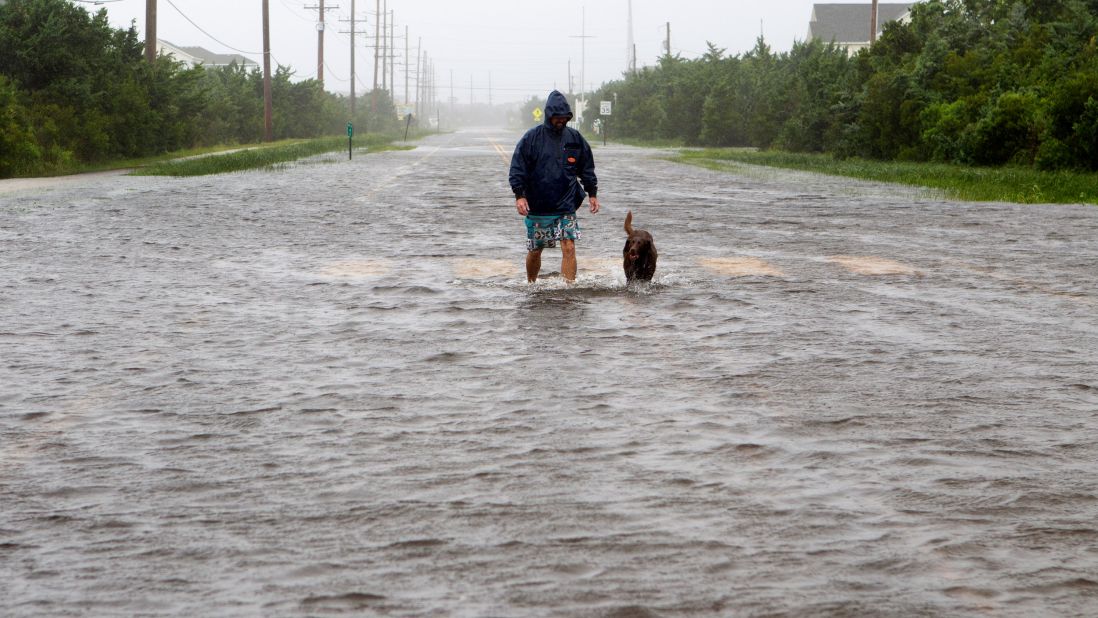 Bryan Philips walks with his dog on a flooded road in Salvo, North Carolina, on September 6.