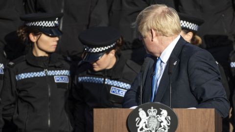 Britain's Prime Minister Boris Johnson reacts as an officer fell unwell during his speech.
