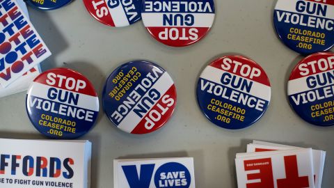 Pins and stickers advocating to stop gun violence are on display during the Gun Safety Town Hall on Monday, August 26 in Aurora, Colorado.