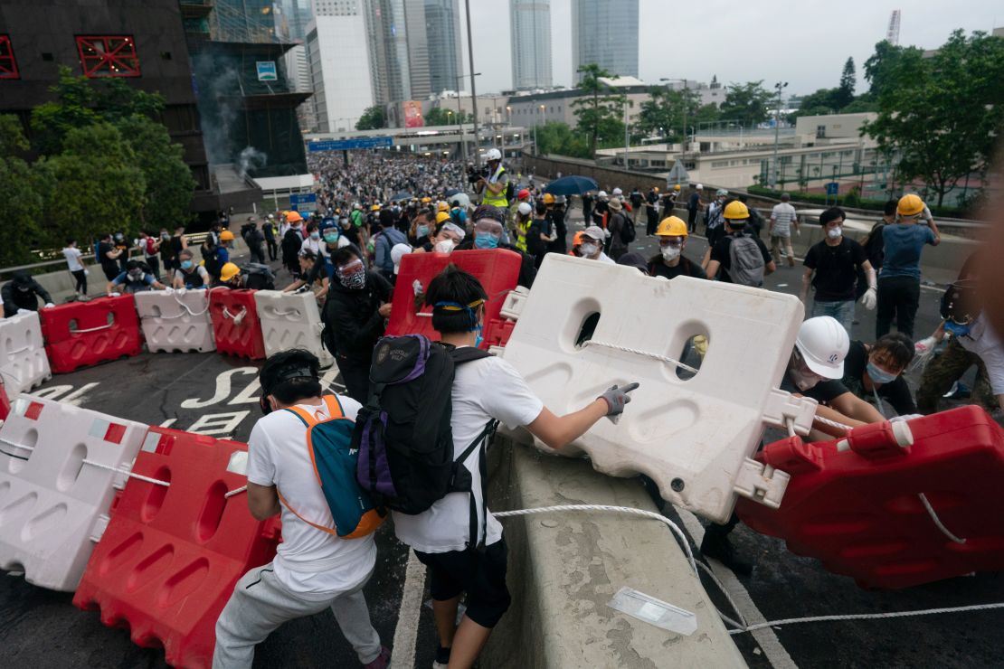 Protesters move barricades to block a street during the June 12 protest.