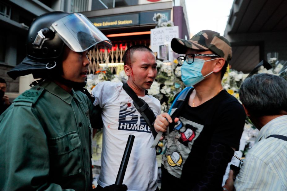 Police escort an injured man after he attacked protesters outside Prince Edward station in Hong Kong on Friday, September 6.