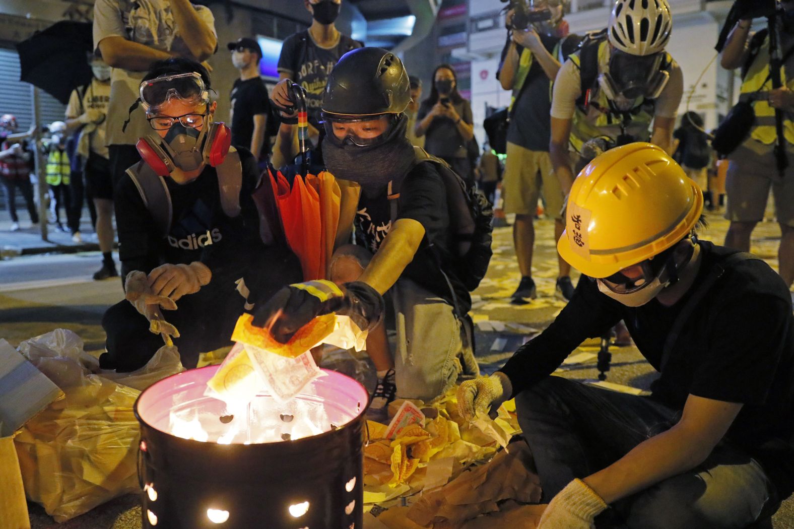 Protesters burn paper money to pay their respects to injured protesters.