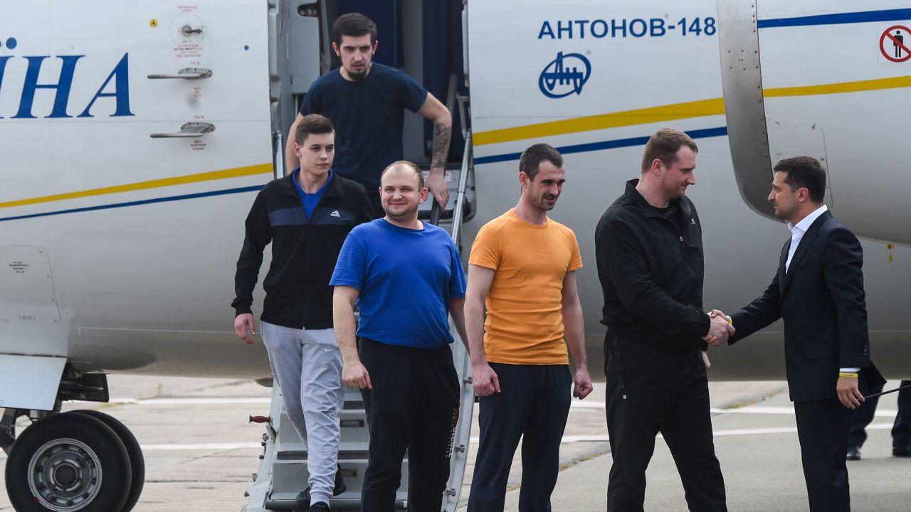 Ukraine's President Volodymyr Zelensky welcomes former prisoners as they disembark from the plane.