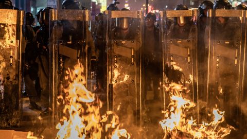 Riot police stand in front a barricade set on fire by protesters after dispersing crowds outside the Mong Kok Police Station on September 7.