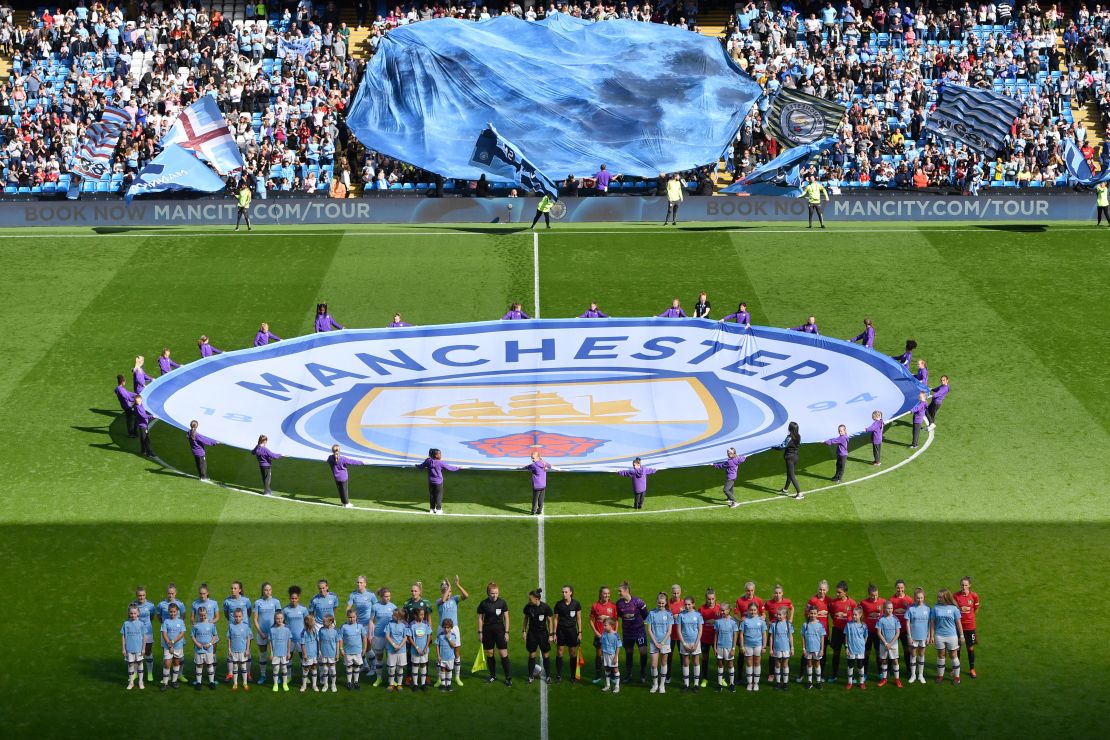 The two teams line up prior to the historic first meeting between the Manchester clubs.