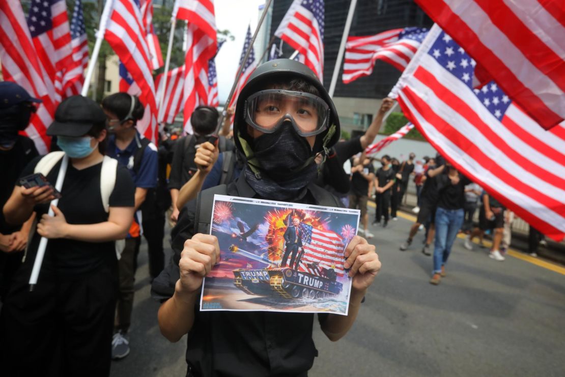 A man holds a placard as protesters wave US national flags while they march from Chater Garden to the US Consulate in Hong Kong on September 8.