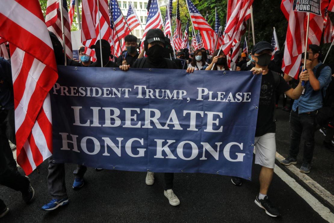Protesters hold a banner and wave US national flags as they march to the US Consulate in Hong Kong on September 8.