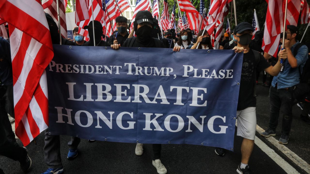 Protesters hold a banner and wave US national flags as they march to the US Consulate in Hong Kong on September 8.