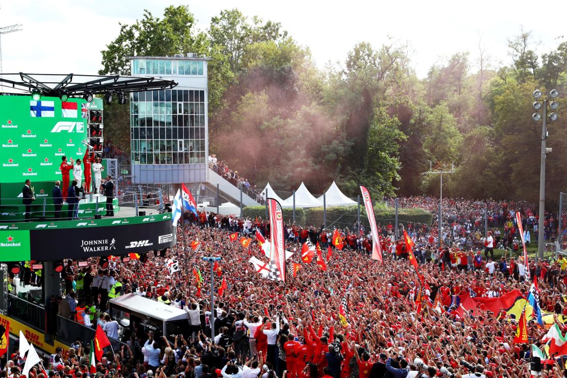 Leclerc stands on the podium in front of a sea of Ferrari fans. 