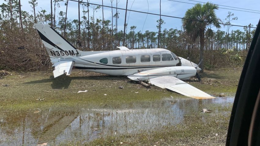A plane destroyed by Hurricane Dorian sits by the side of the road near the Freeport Airport.