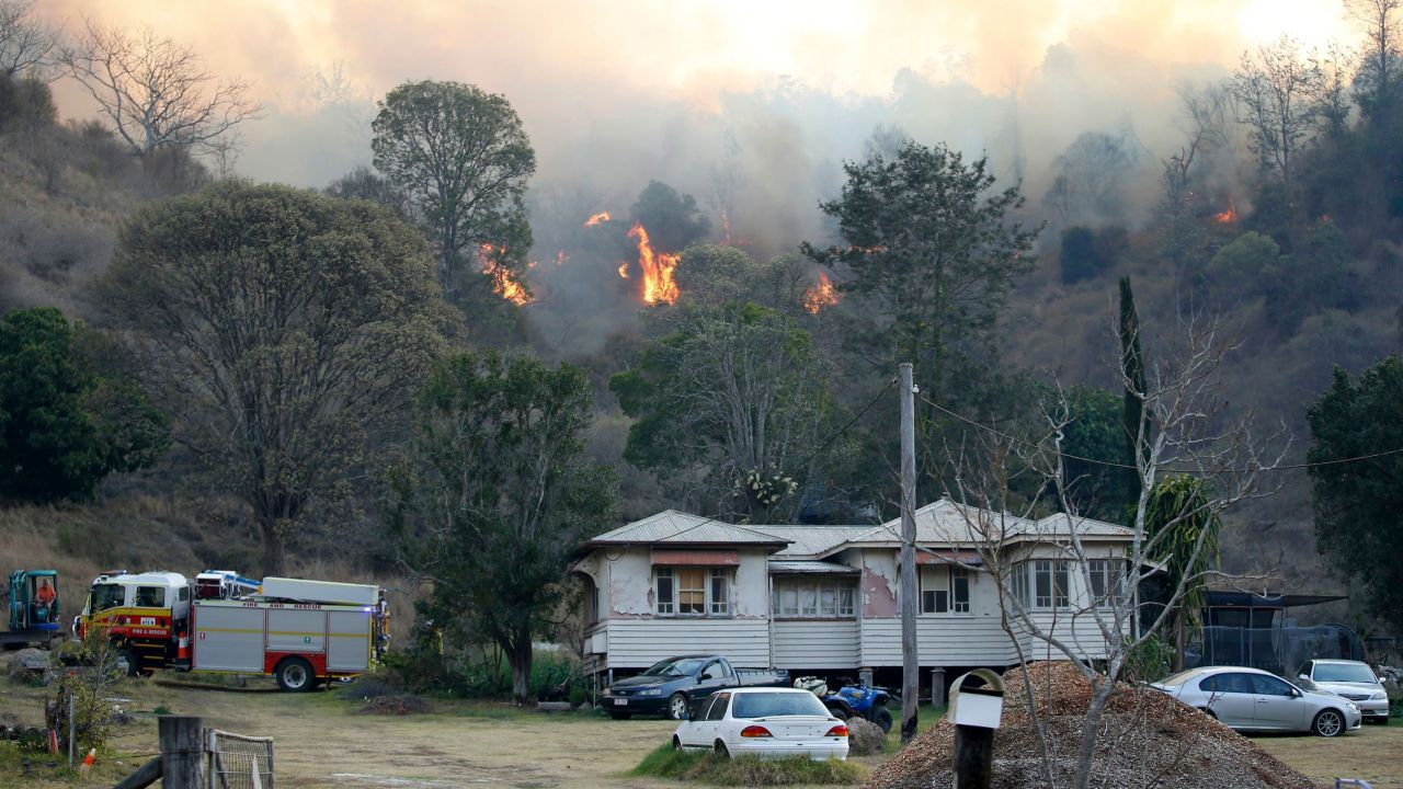 Fire and emergency crew battle a bushfire near a house in the rural town of Canungra in southeast Queensland, Australia, on September 6, 2019. 