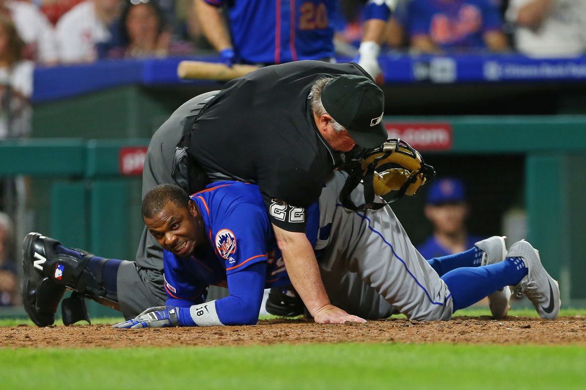 Home plate umpire Joe West falls on top of Mets player Rajai Davis after he was tagged out at home during the eighth inning of an MLB game at Citizens Bank Park in Philadelphia on September 1.
