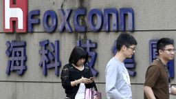 People walk past a Foxconn logo in Taipei on January 31, 2019. 