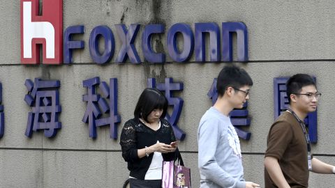 People walking past a Foxconn logo in Taipei.