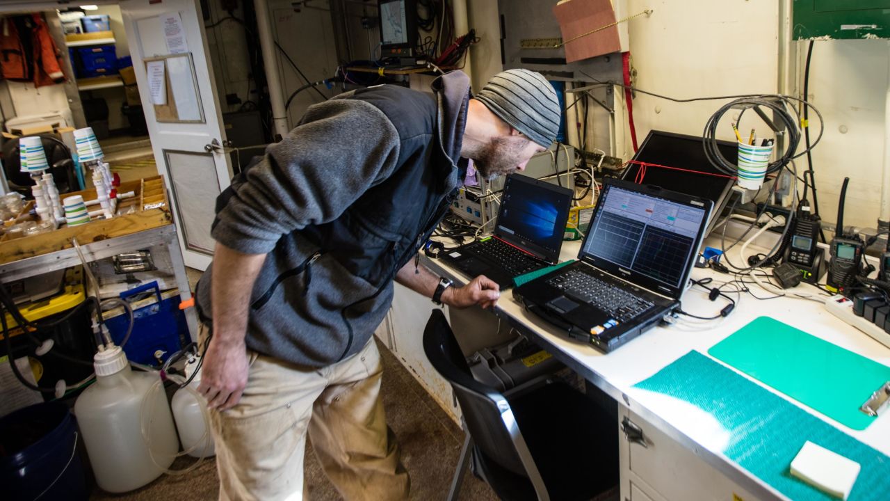Ryan McCabe, on board a NOAA research vessel, examines data from the warming Arctic seas.