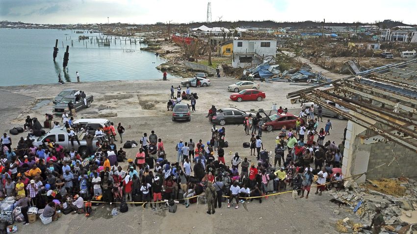 Evacuees gather at Marsh Harbour Port in Abaco, Bahamas, Friday, Sept. 6, 2019. Carrying their meager possessions in duffel bags and shopping carts, hundreds of desperate storm victims gathered at the port in Grand Abaco on Friday in hopes of getting off the hurricane-devastated island, amid signs of rising frustration over the pace of the disaster-relief effort. (Al Diaz/Miami Herald via AP)