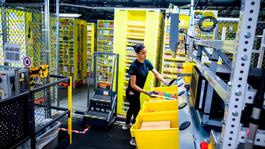 A woman works at a distrubiton station at the 855,000-square-foot Amazon fulfillment center in Staten Island, one of the five boroughs of New York City, on February 5, 2019. - Inside a huge warehouse on Staten Island thousands of robots are busy distributing thousands of items sold by the giant of online sales, Amazon. (Photo by Johannes EISELE / AFP)        (Photo credit should read JOHANNES EISELE/AFP/Getty Images)