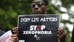 A demonstrator holds a sign during a protest against xenophobia outside of the main gate of the South African High Commission which was shut down to avert reprisal attacks in Abuja, on September 5, 2019. - South Africa said on September 5, 2019 it had temporarily closed its diplomatic missions in Nigeria following violence against South African businesses carried out in reprisal for attacks on foreign-owned stores in Johannesburg. (Photo by KOLA SULAIMON / AFP)        (Photo credit should read KOLA SULAIMON/AFP/Getty Images)