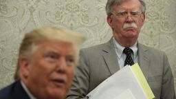 President Donald Trump speaks to members of the media as National Security Adviser John Bolton listens during a meeting with President of Romania Klaus Iohannis in the Oval Office of the White House August 20, 2019 in Washington, DC. 