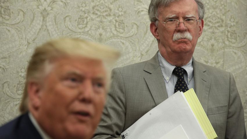 President Donald Trump speaks to members of the media as National Security Adviser John Bolton listens during a meeting with President of Romania Klaus Iohannis in the Oval Office of the White House August 20, 2019 in Washington, DC.