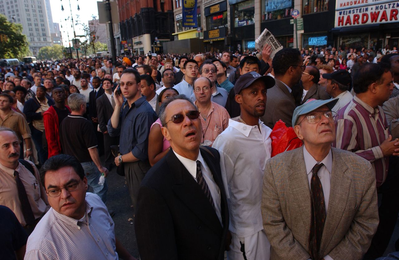 People in New York look up as the World Trade Center burns.