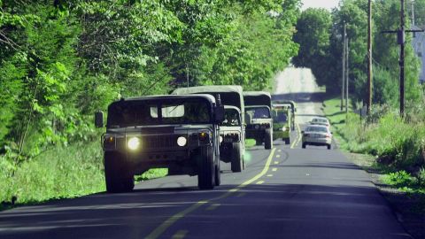 Military vehicles travel along the road leading to the crash site of Flight 93.
