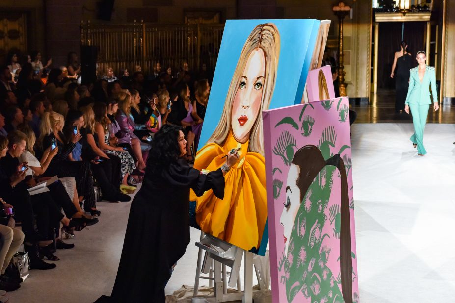 Artist Ashley Longshore paints during the Christian Siriano show at Gotham Hall on September 7, 2019 in New York City. 