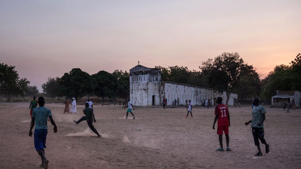 Teenagers play football in front of the church of Birao, northern Central African Republic.