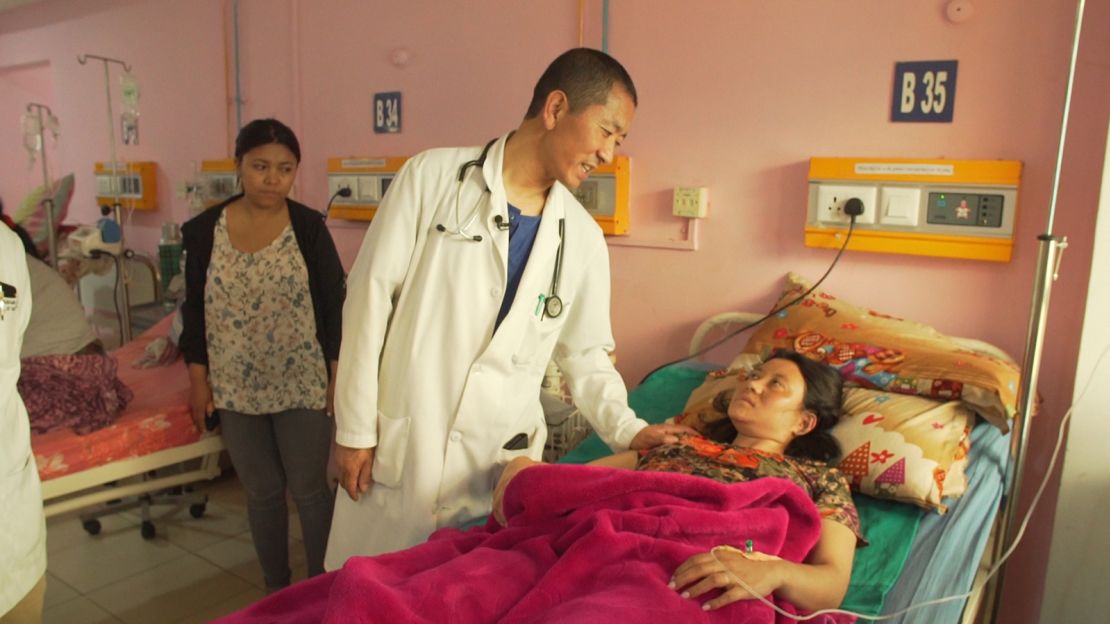 Tshering visits with a patient on hospital rounds.