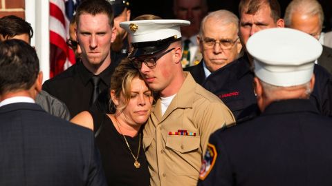 Michael Haub comforts his mother, Erika Starke, as they attend a funeral service for his father,  firefighter Michael Haub. 