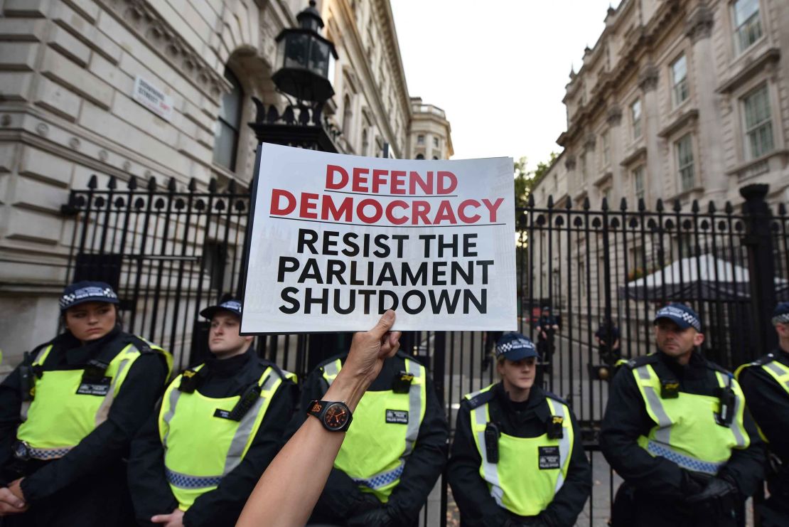 A protester holds a placard at the gates of Downing Street during a demonstration against the UK Government's decision to  prorogue parliament.