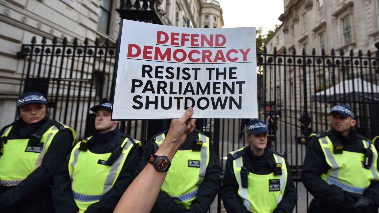A protester holds a placard at the gates of Downing Street during a demonstration against the UK Government's decision to prorogue parliament.