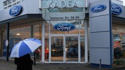 BERLIN, GERMANY - JANUARY 11: A man with an umbrella walks past a Ford car dealership on January 11, 2019 in Berlin, Germany. Ford recently announced that it will shed thousands of jobs in Europe.  (Photo by Sean Gallup/Getty Images)