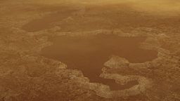 This artist's concept of a lake at the north pole of Saturn's moon Titan illustrates raised rims and rampartlike features such as those seen by NASA's Cassini spacecraft around the moon's Winnipeg Lacus. New research using Cassini radar data and modeling proposes that lake basins like these are likely explosion craters, which could have formed when liquid molecular nitrogen deposits within the crust warmed and quickly turned to vapor, blowing holes in the moon's crust. This would have happened during a warming event (or events) that occurred in a colder, nitrogen-dominated period in Titan's past. The new research may provide evidence of these cold periods in Titan's past, followed by a relative warming to conditions like those of today. Although Titan is frigid compared to Earth, methane in the atmosphere provides a greenhouse effect that warms the moon's surface.The Cassini mission is a cooperative project of NASA, ESA (the European Space Agency) and the Italian Space Agency. The Jet Propulsion Laboratory, a division of the California Institute of Technology in Pasadena, manages the mission for NASA's Science Mission Directorate, Washington. The Cassini orbiter and its two onboard cameras were designed, developed and assembled at JPL. The imaging operations center is based at the Space Science Institute in Boulder, Colorado.