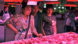 Customers shop for pork at a market in Beijing on September 5, 2019.