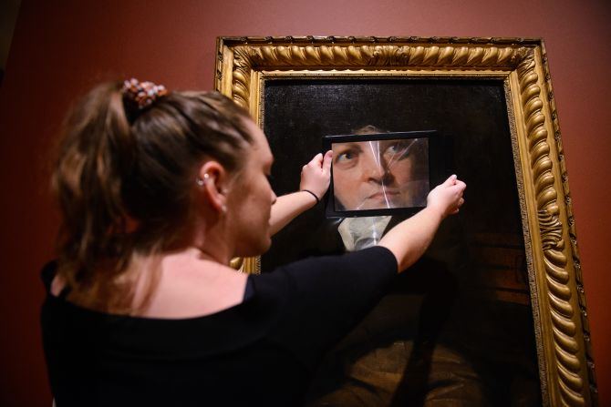 A woman takes a closer look at a William Blake painting during an exhibition at the Tate Britain art museum in London on Monday, September 9.