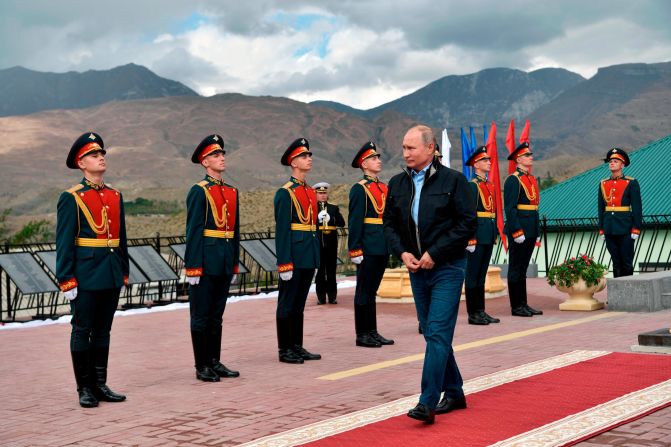 Russian President Vladimir Putin walks past honor guards after laying flowers at a monument in Botlikh, Russia, on Thursday, September 12.