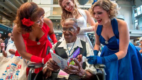Singing group The Victory Belles give World War II veteran Lawrence Brooks a birthday card.