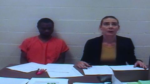 Tevin Biles-Thomas sat at a table in jail Friday as he monitored his court hearing by video.