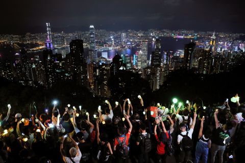 Demonstrators hold up their cell phone lights as they form a human chain at the Peak, a tourist spot in Hong Kong, on September 13.