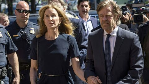 Actress Felicity Huffman, escorted by her husband William H. Macy, makes her way to the federal courthouse in Boston on Friday.