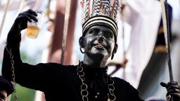 A man wearing a controversial makeup colouring blackface and called "the savage" gestures during a folk parade "Ducasse" of Ath in Ath, Belgium on August 25, 2019. - Anti-racism campaigners have called on Unesco to remove a Belgian folklore festival from its cultural heritage list unless organisers stop parading characters in blackface. The four-day carnival in the Belgian town of Ath,  features the savage, a white man in blackface, who wears a chain around his neck and a ring through his nose. According to the official festival website, the savage, chained and agitated, testifies to the taste for the exotic of the 19th century. (Photo by Kenzo TRIBOUILLARD / AFP)        (Photo credit should read KENZO TRIBOUILLARD/AFP/Getty Images)
