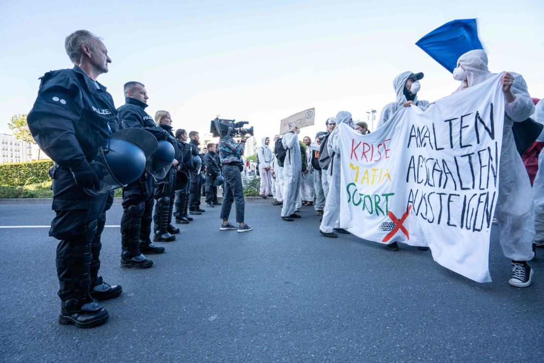 Demonstrators from the action group Sand im Getriebe (Sand in the Gearbox) faced police officers as they blocked a road in Frankfurt.