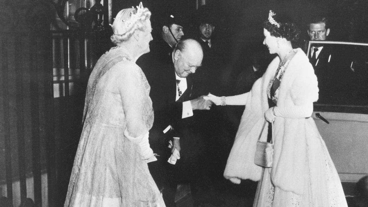 Winston Churchill kisses Queen Elizabeth II's (R) hand as she leaves 10 Downing Street in 1955.