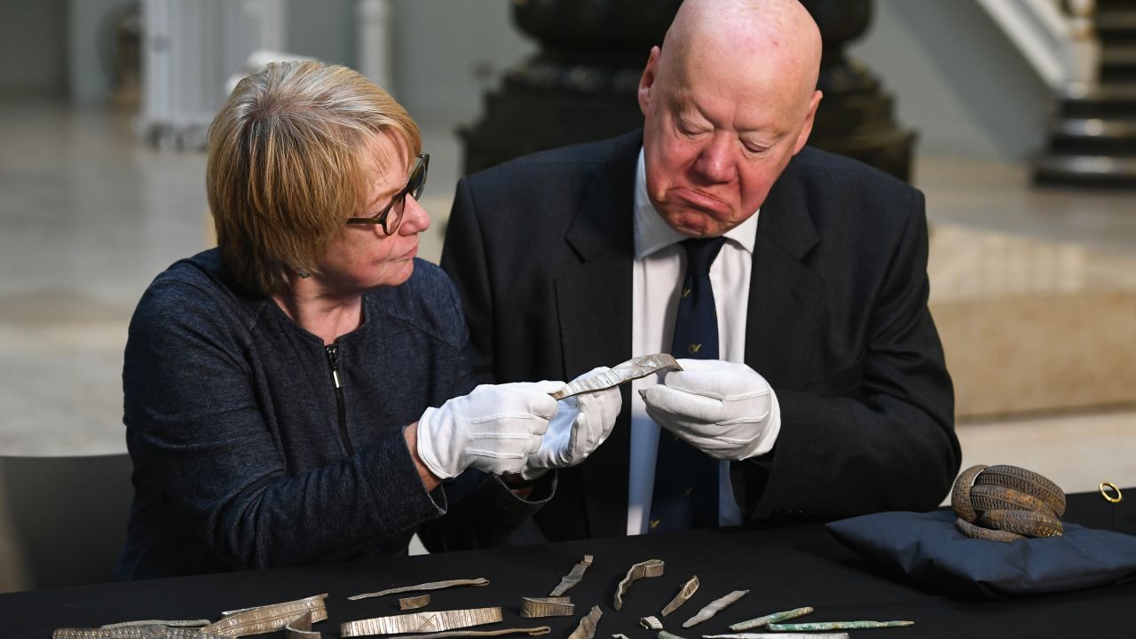 Bruce Minto, Chairman of the Board of Trustees of National Museums, and Seona Reid, deputy chair of the National Heritage Memorial Fund, view treasures from the Galloway Hoard at the National Museums of Scotland on October 26, 2017 in Edinburgh.