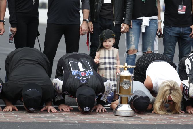 Piper Harvick, the daughter of NASCAR driver Kevin Harvick, stands next to her dad, second from left, after he won a Cup Series race at Indianapolis Motor Speedway on Sunday, September 8.