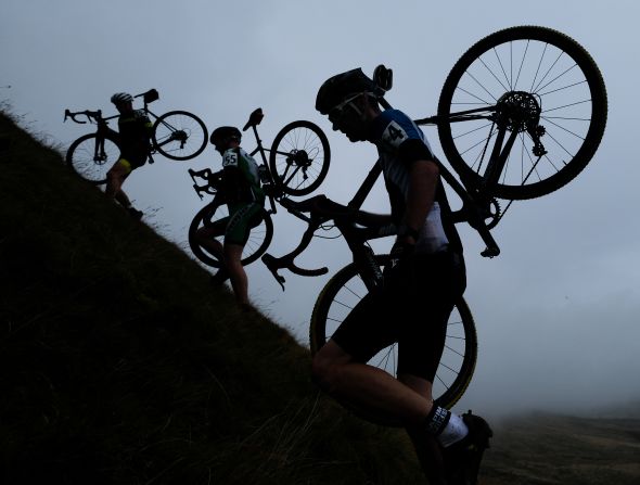 Cyclocross competitors carry their bicycles up a hill in Settle, England, on Sunday, September 15.