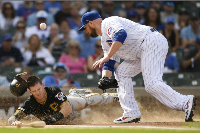 Pittsburgh's Kevin Newman slides safely into home plate as Chicago Cubs pitcher Jon Lester tries to make a tag on Friday, September 13. 