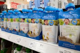 Bellamy's Organic baby food packages in different flavors on supermarket shelf.