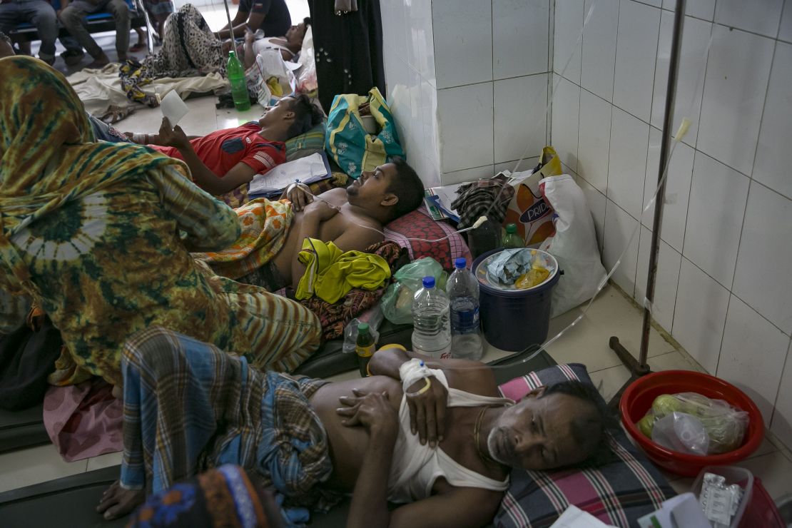 Bangladeshi patients suffering from dengue fever rest on the floor of a hospital ward in Dkaha. 